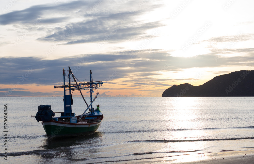 Naklejka premium fishing boat in a morning on the beach sunrise