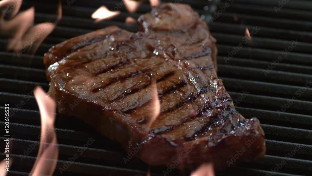 T-Bone steak on grill in slow motion, shot on Phantom Flex 4K