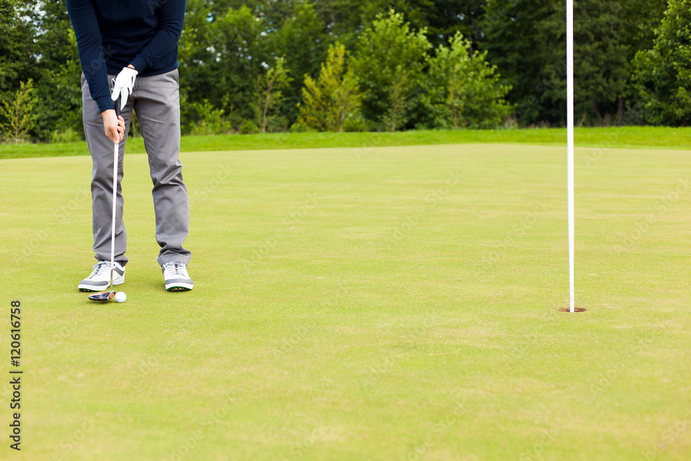 Obraz premium Male golf player drivers the ball into the hole