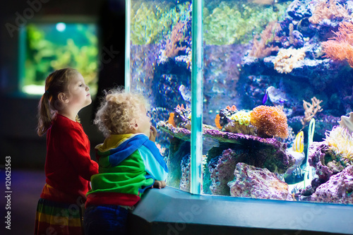 Kids watching fish in tropical aquarium Fototapeta