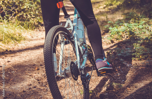 Woman riding a bike in the forest. Bicycle gear