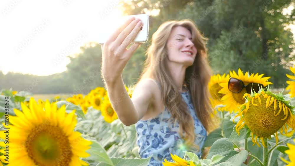 Beautiful young girl doing selfie among sunflowers. HD Beautiful young girl doing selfie among sunflowers. HD