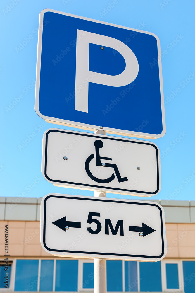Close-up of a handicapped parking sign against blue sky Close-up of a handicapped parking sign against blue sky