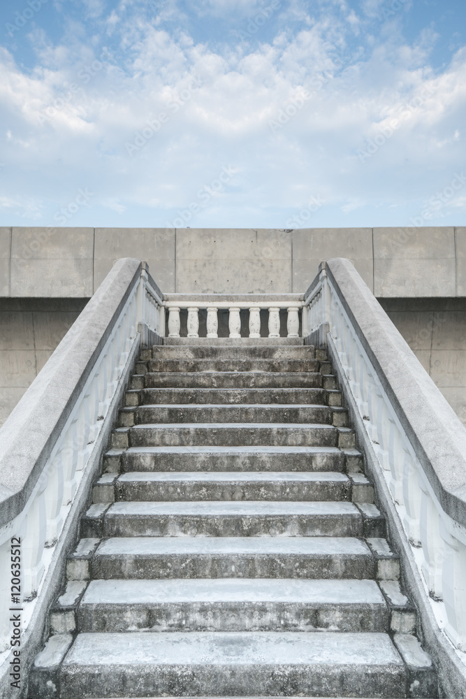 Fototapeta premium Bottom view stairs of white stonemason bridge against the blue cloudy sky during summer day