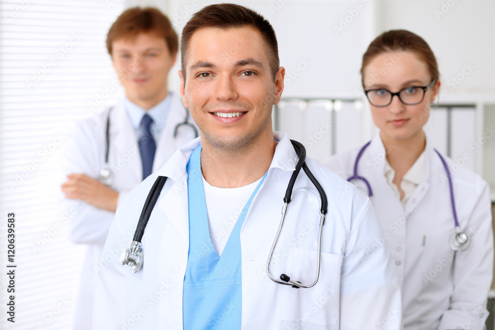 Cheerful smiling male doctor with medical staff at the hospital Cheerful smiling male doctor with medical staff at the hospital