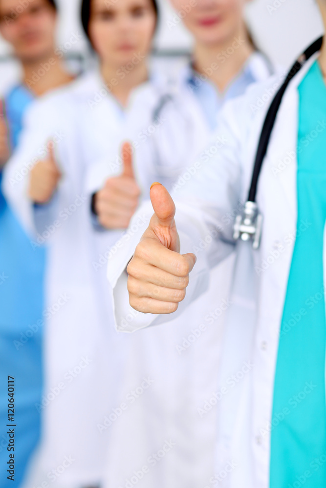 Group of doctors showing OK or approval sign with thumb up. High level and quality medical service, best treatment and patient care concept Group of doctors showing OK or approval sign with thumb up. High level and quality medical service, best treatment and patient care concept