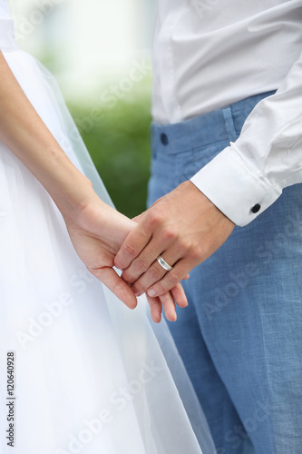 Bride and groom holding hands together outdoor