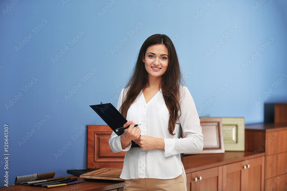Beautiful female designer with clipboard in office Beautiful female designer with clipboard in office