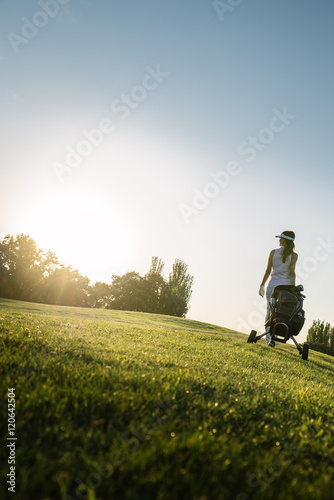 Pretty young woman playing golf.