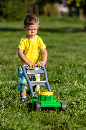 child mowing grass