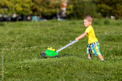 child mowing grass