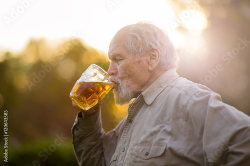 Пенсионер пьет пиво на природе