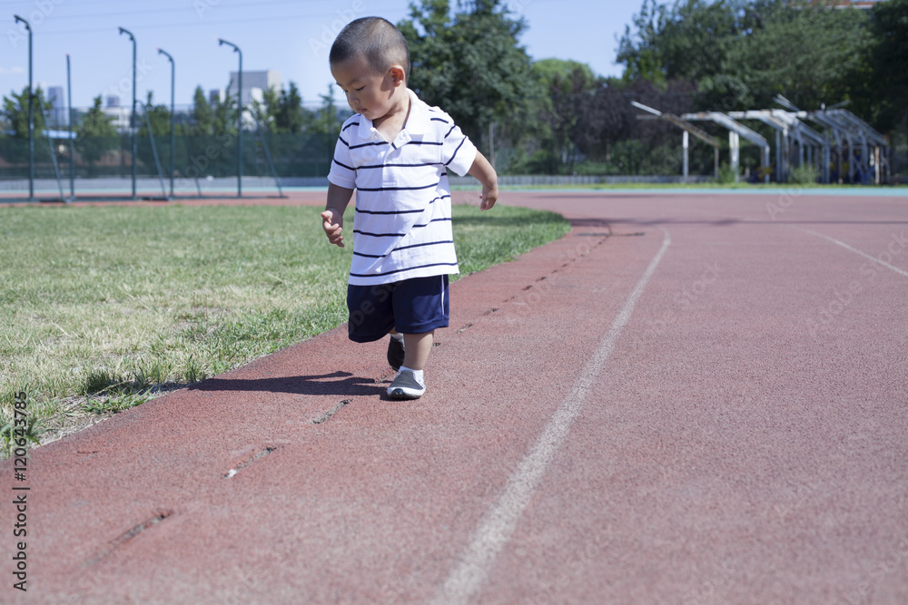 Cute Chinese baby boy playing in a stadium