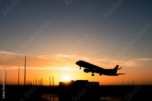 Photography Commercial airplane taking off during sunset over a marina