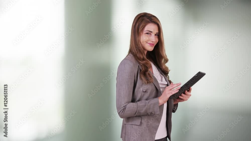 Attractive business woman intern using tablet in the office. Cute Woman in 20s using pad in the hallway