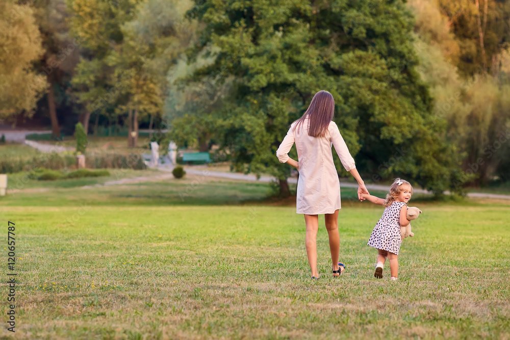 The concept of Mother's Day. Mother with little daughter walking The concept of Mother's Day. Mother with little daughter walking