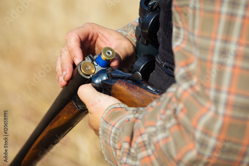 Close-up of a hunter loading his shotgun