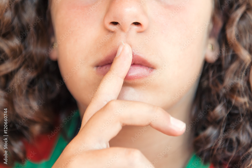 Girl holding finger to lips, gesture for silence Girl holding finger to lips, gesture for silence