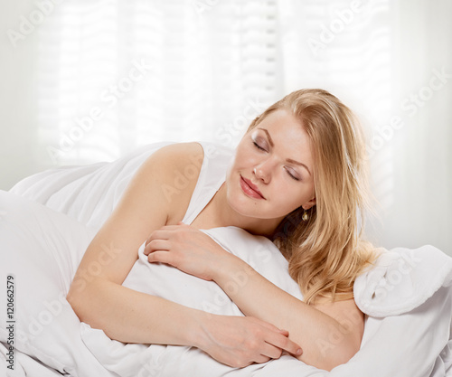 woman Pleasure in the bed with closed eyes