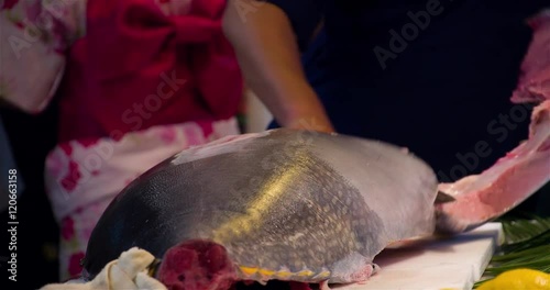 Cutting fresh whole Bluefin Tuna fish close up video. Chef cook hands with knife. Asian japanese cuisine.