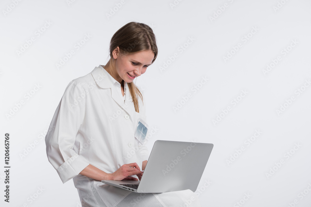 Smiling female doctor working on her laptop against a white background Smiling female doctor working on her laptop against a white background