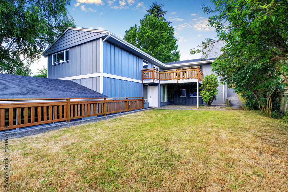 Obraz premium Spacious wooden fenced backyard area. Countryside blue house.