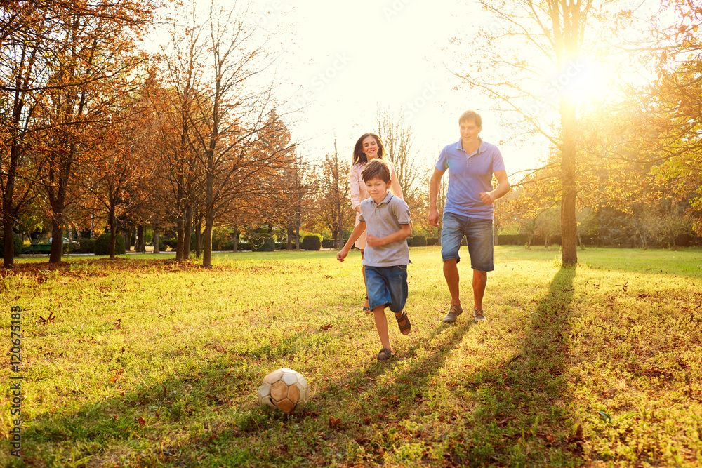 Fototapeta premium Happy family playing in nature late afternoon sunlight in the fa