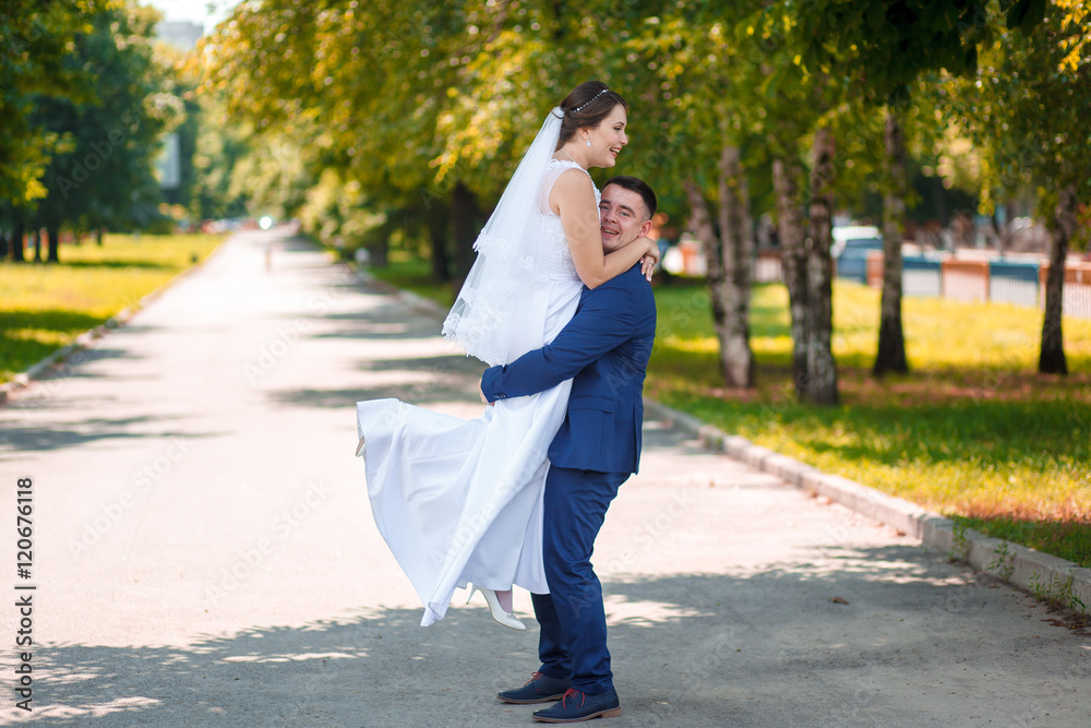 Elegant bride and groom posing together outdoors on a wedding day Elegant bride and groom posing together outdoors on a wedding day