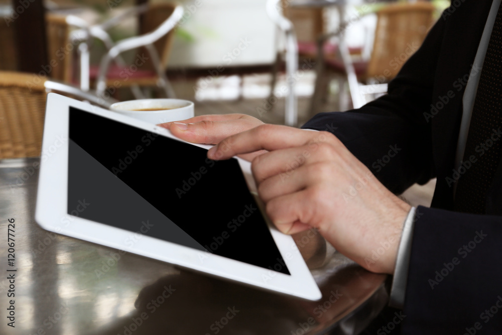 Businessman with tablet in cafe
