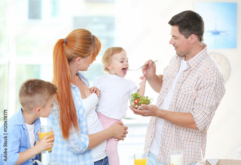 Father feeding little daughter in kitchen Father feeding little daughter in kitchen