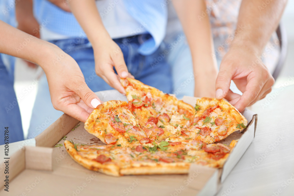 Hands taking pizza from table, closeup
