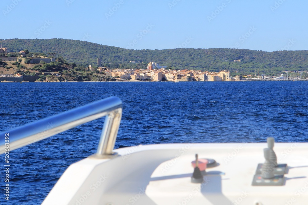 Obraz premium Distant view of Saint Tropez on the Mediterranean coast of France seen from an approaching ferry boat in blurred foreground