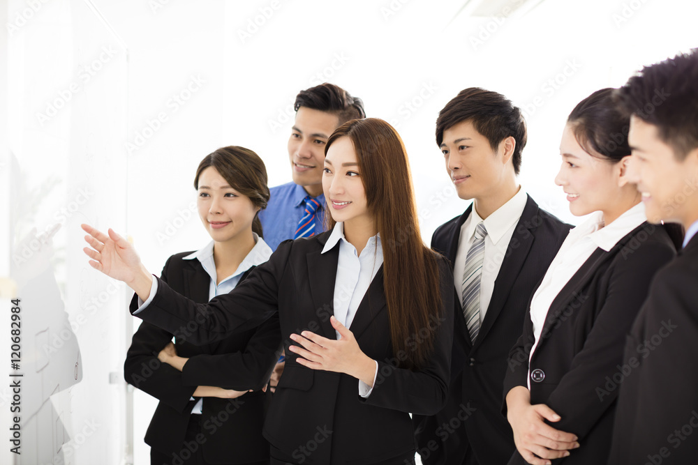 Businesswoman presenting new project to partners in office Businesswoman presenting new project to partners in office