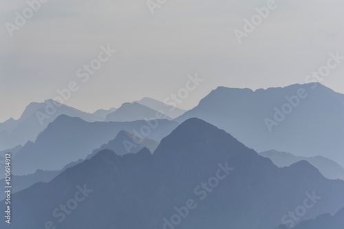 Silhouette of blue mountains in the fog. View of Moldoveanu peak, the highest peak from Romanian Carpathian Mountains range. Seamless background.