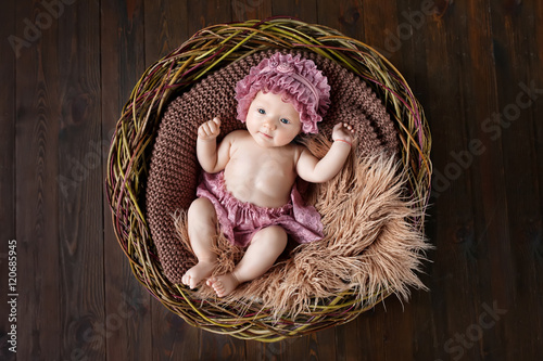 Lovely little girl lies in a basket