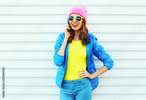 Fashion happy cool smiling girl talking on smartphone in colorfu
