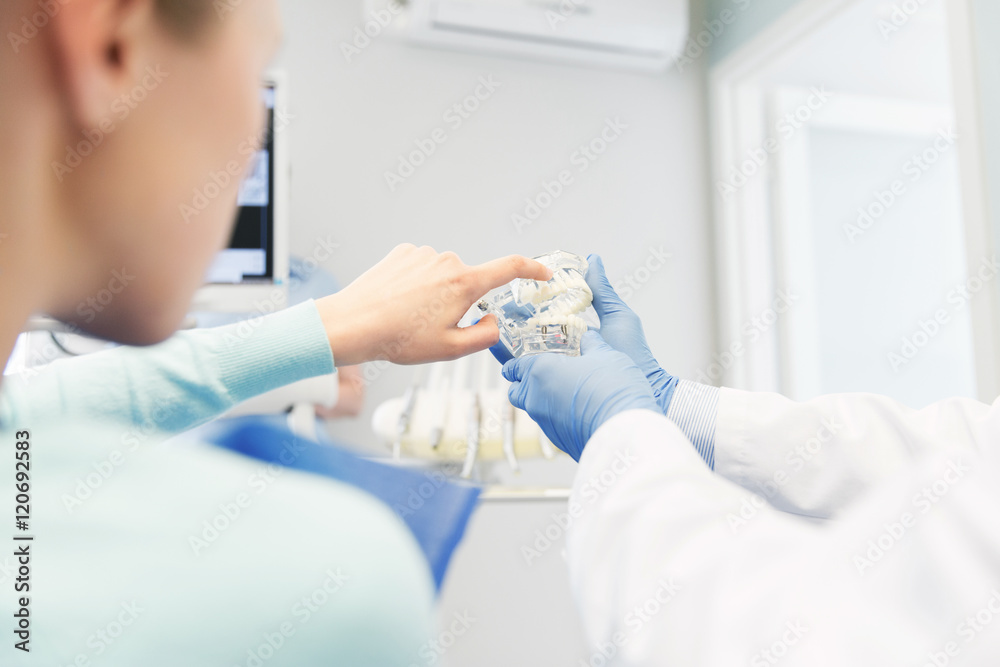 close up of dentist with teeth model and patient close up of dentist with teeth model and patient