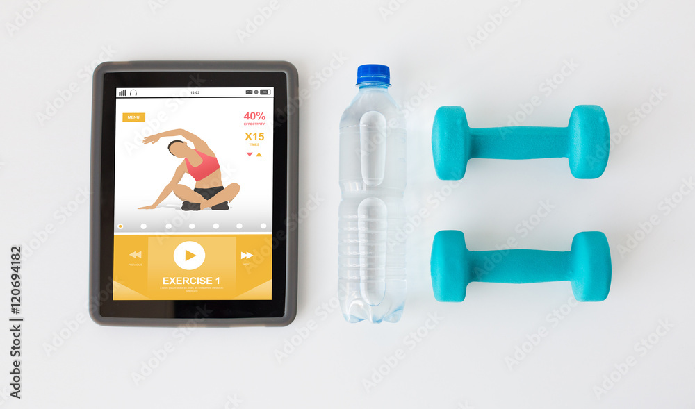 close up of tablet pc, dumbbells and water bottle close up of tablet pc, dumbbells and water bottle