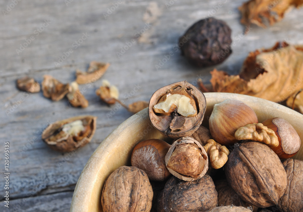 noix et noisettes décortiquées dans un bol sur fond en bois noix et noisettes décortiquées dans un bol sur fond en bois