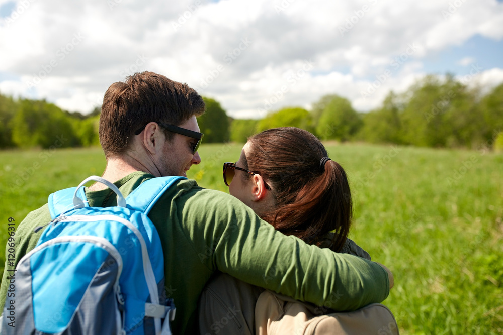 happy couple with backpacks hiking outdoors
