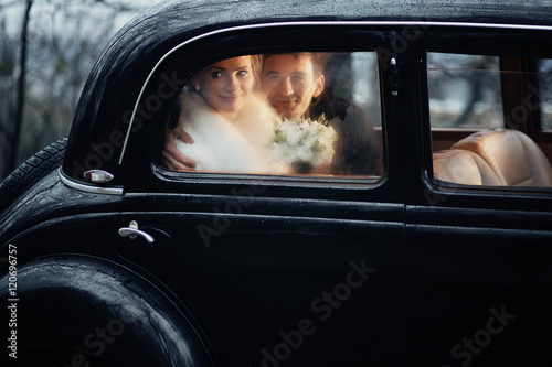 young and beautiful couple sitting in the wedding cortege