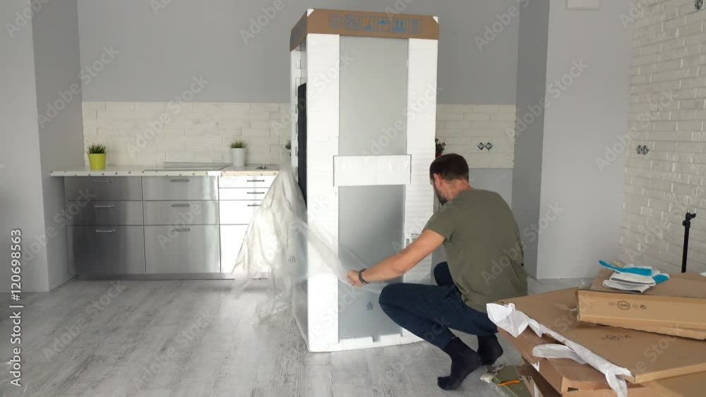 Young man unpacking new fridge from box at home
Young man unpacking new fridge from box at home