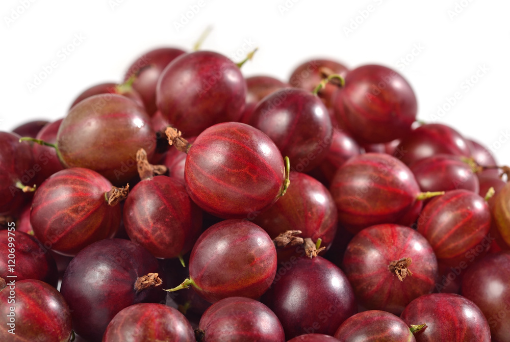 Heap of fresh red gooseberry close up on a white Heap of fresh red gooseberry close up on a white