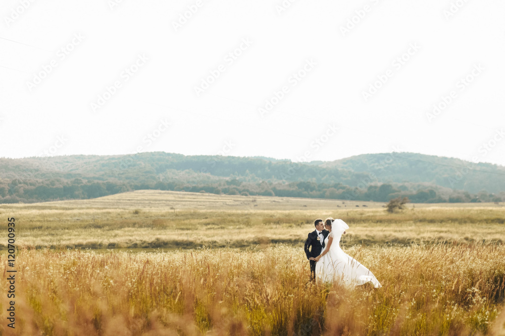 happy husband and wife walking together in field