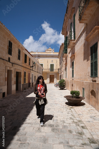 woman walking in street of Ciutadella city in Minorca © Q