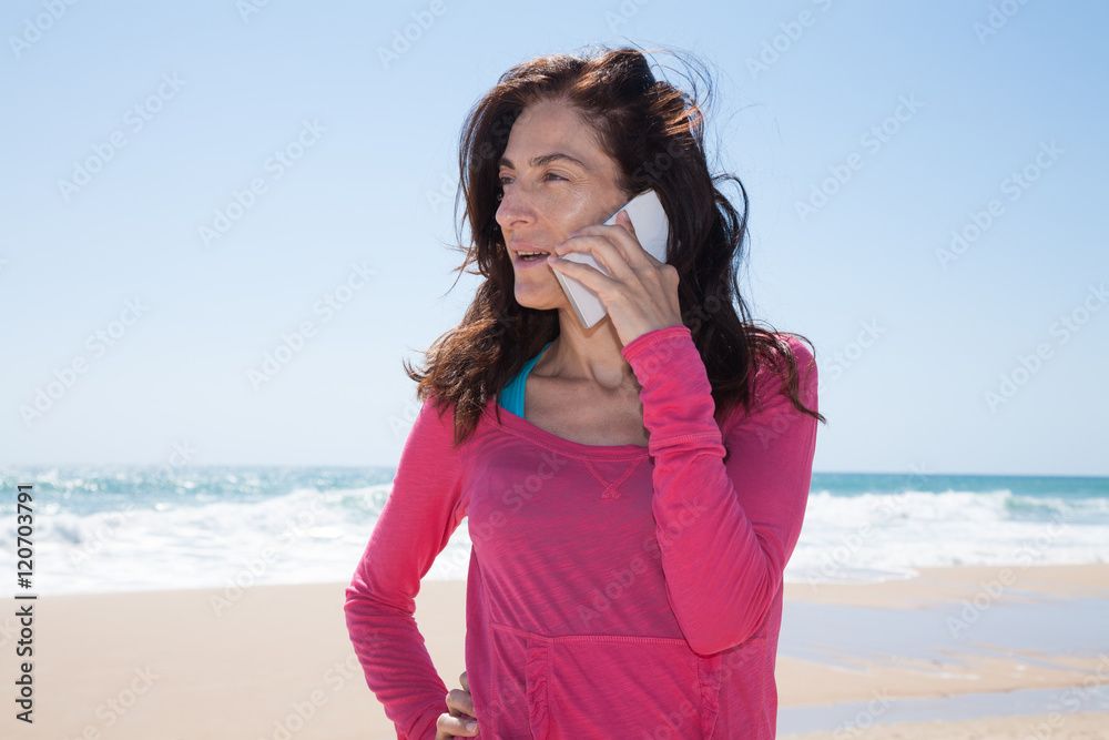 pink shirt woman talking on mobile sea behind pink shirt woman talking on mobile sea behind