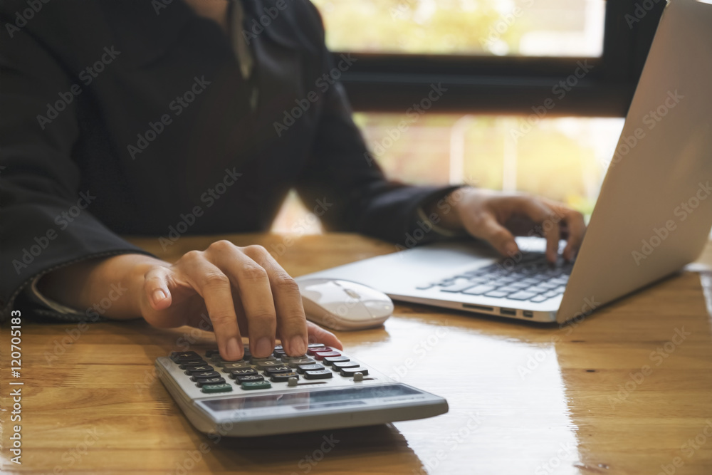 Asian Business woman using a calculator to calculate the numbers Asian Business woman using a calculator to calculate the numbers