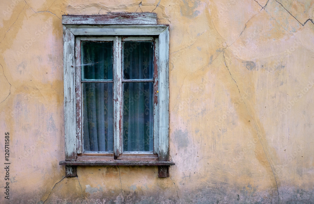 Ветхое деревянное окно со шторами  старого обветшавшего жилого дома 