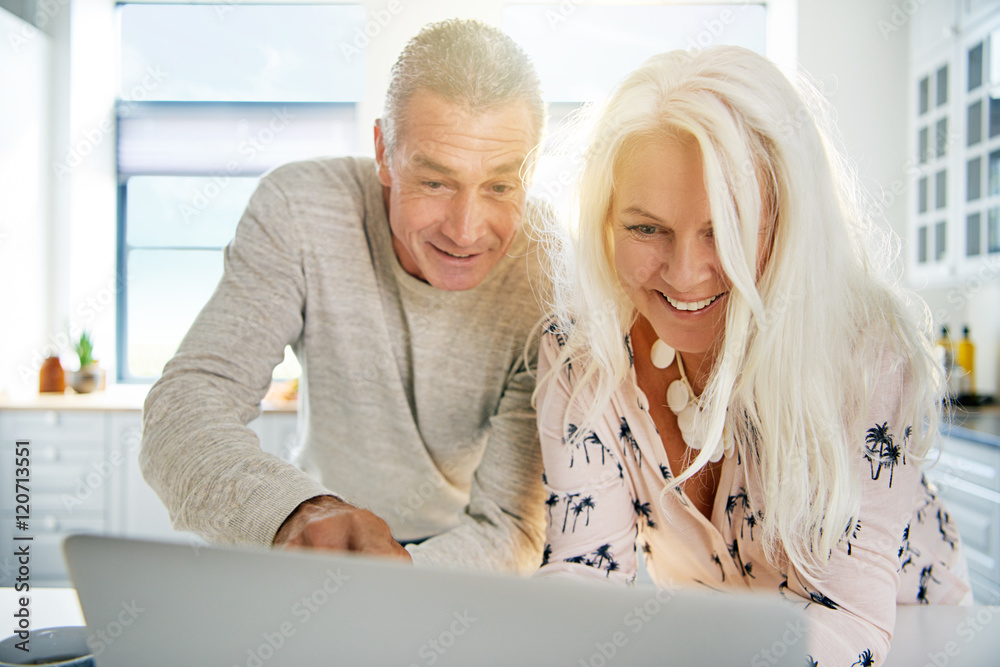 Excited senior couple looking at a laptop together Excited senior couple looking at a laptop together