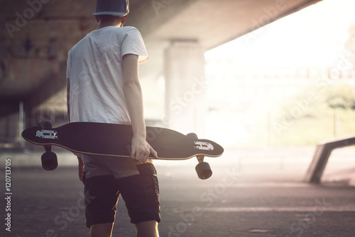 teenager with longboard in the city photo